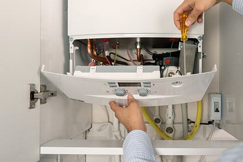 HVAC technician repairing an indoor boiler in Englewood