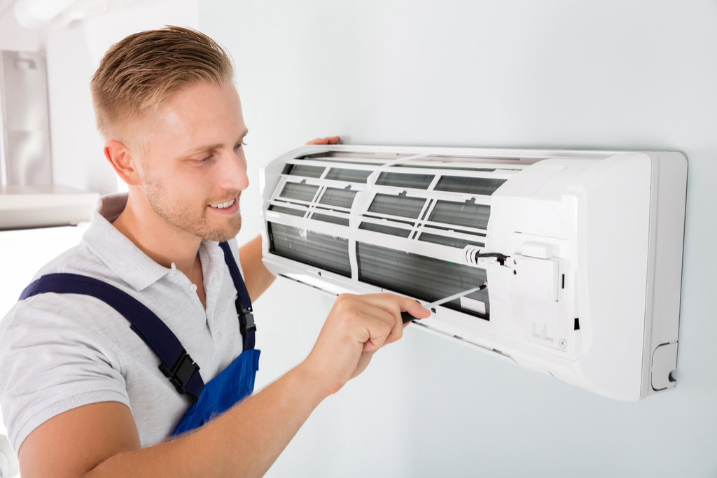 HVAC technician performing ductless air conditioning maintenance in Englewood