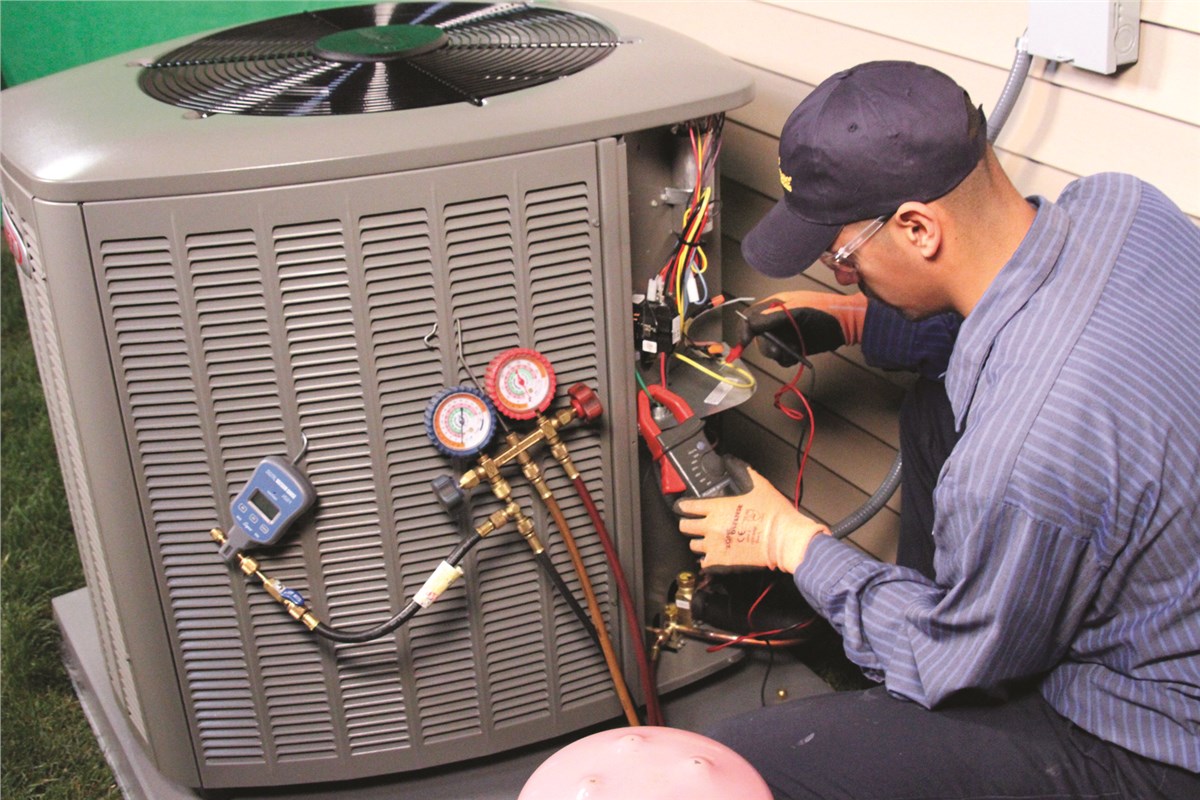 HVAC technician testing an outdoor air conditioning unit in Englewood