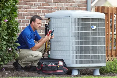 design-air-heating-and-air-conditioning-decatur-il-05 – Copy HVAC technician inspecting an outdoor air conditioning unit in Englewood, CO